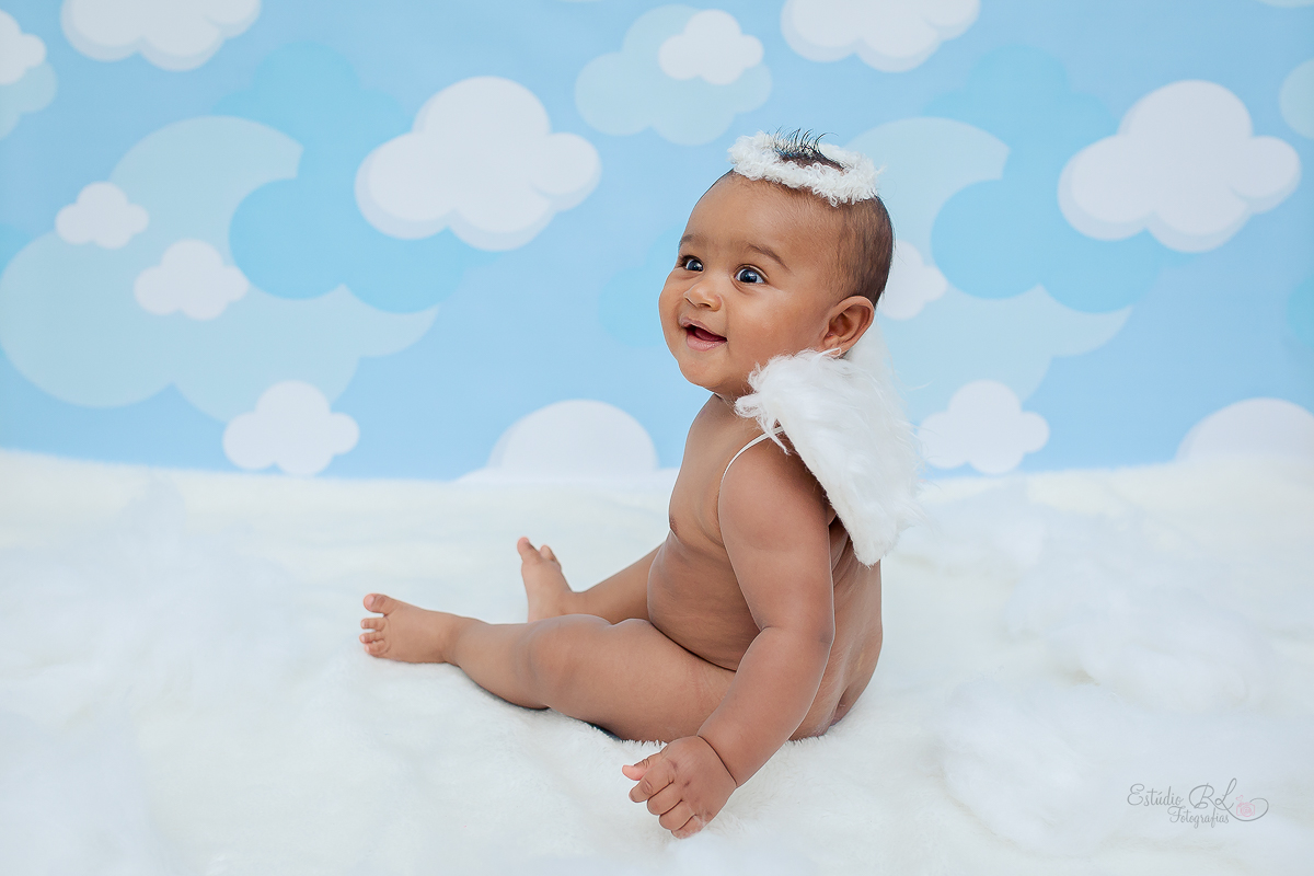 Esse anjinho parece que esta no céu mesmo, com essas nuvens do cenário está muito bonito