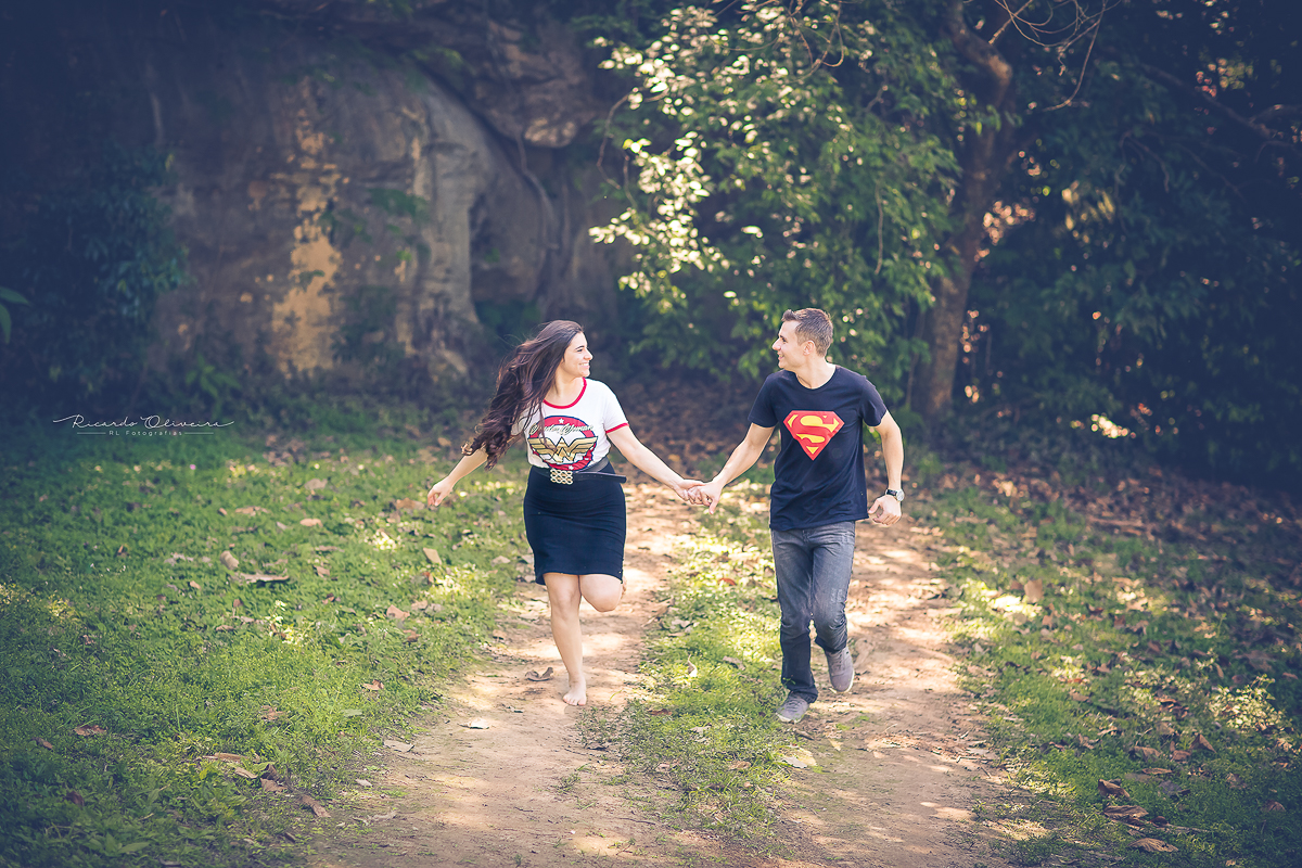 Noivos vestidos de super heróis correndo, um olhando para o outro com olhar apaixonado