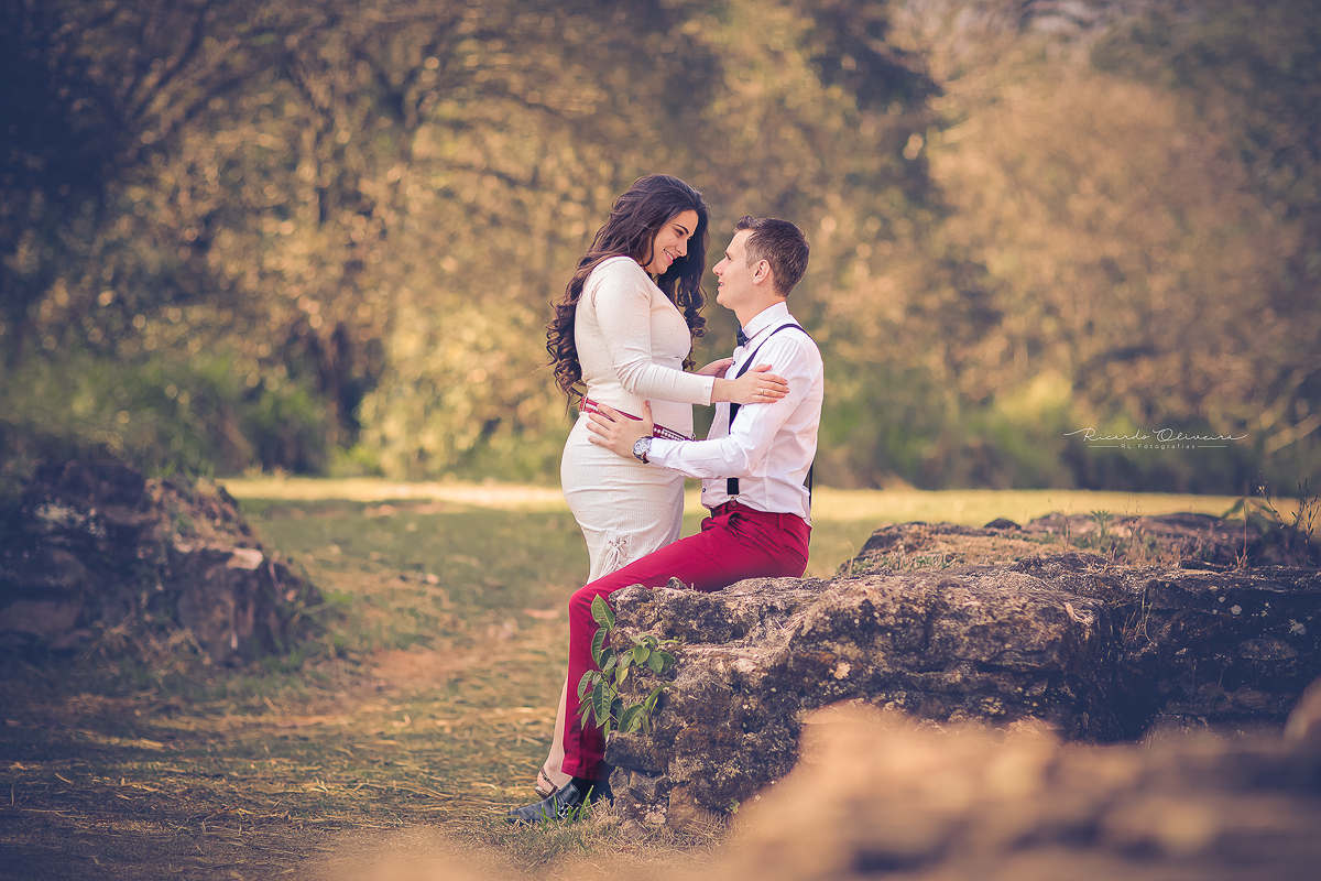 Casal muito apaixonado, com o noivo sentado nas rochas