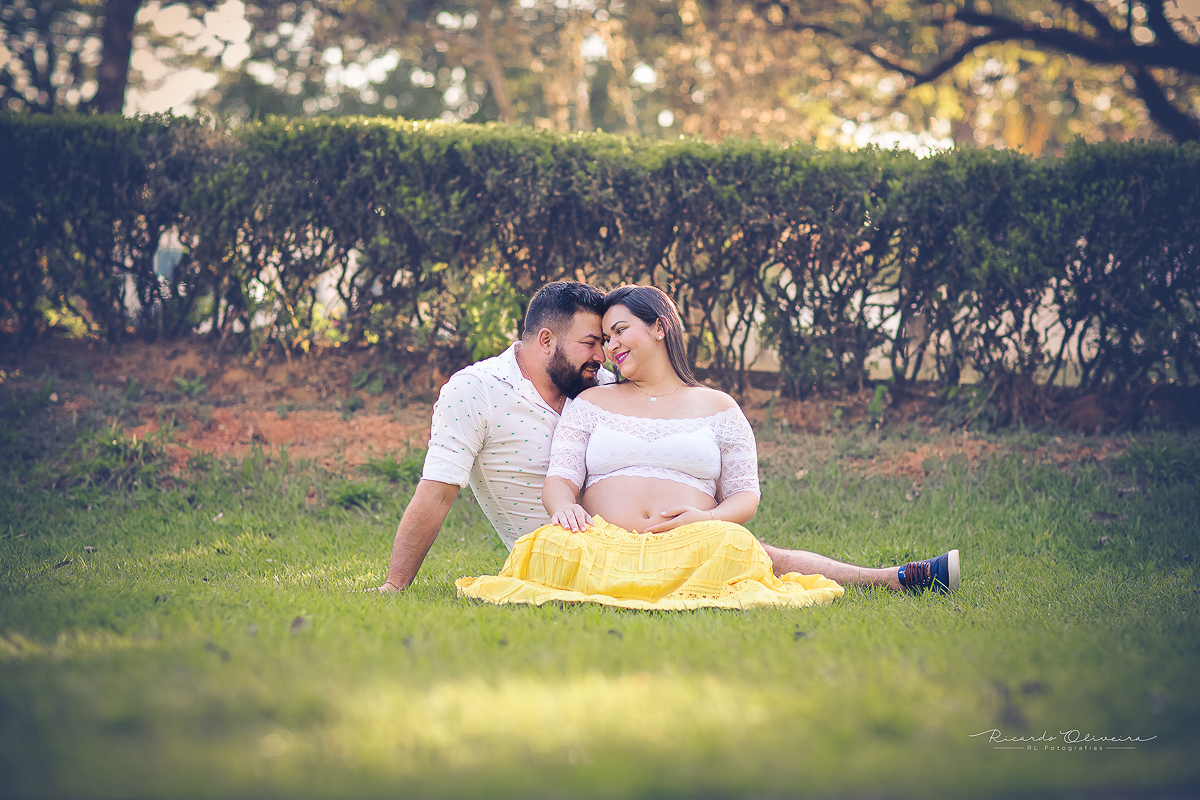 O casal sentado na grama, com um olhar de apaixonados