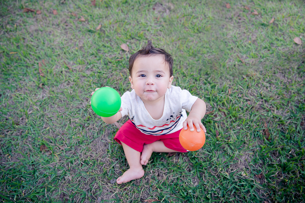 Arthur se divertindo na grama com as bolinhas