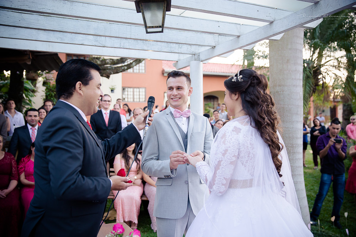 Noivo colocando aliança em noiva