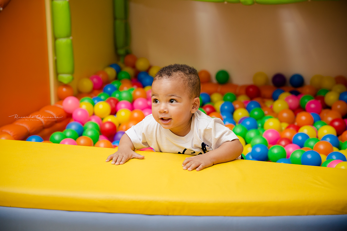 Os meninos brincando na piscina de bolinhas