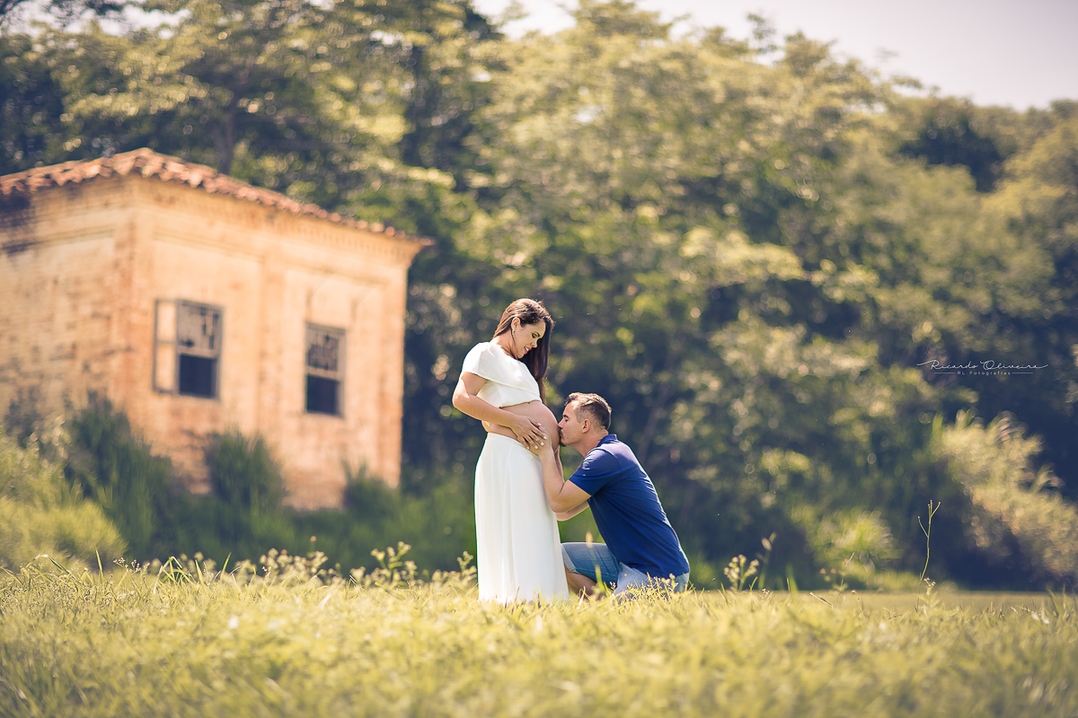 Papai beijando barriga da mamãe, que espera por Caleb