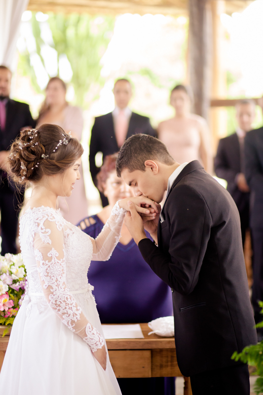noivo beijando as alianças