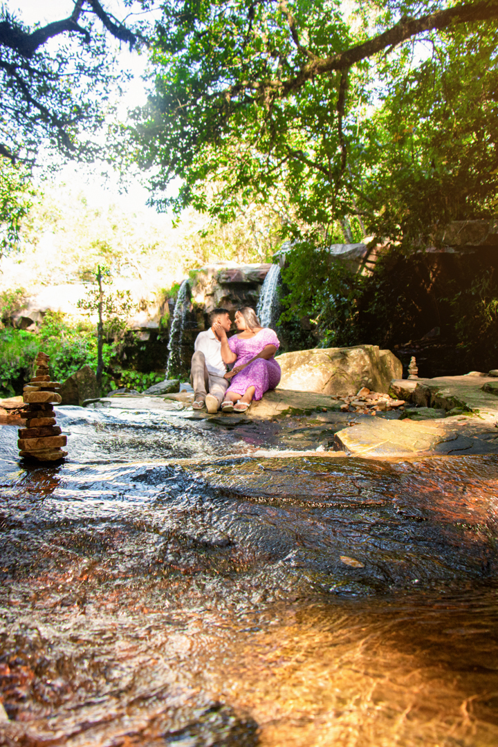 Casal junto  no meio de um riacho   com uma cachoeira no fundo   no vale das borboletas em São Tomé das Letras - MG
