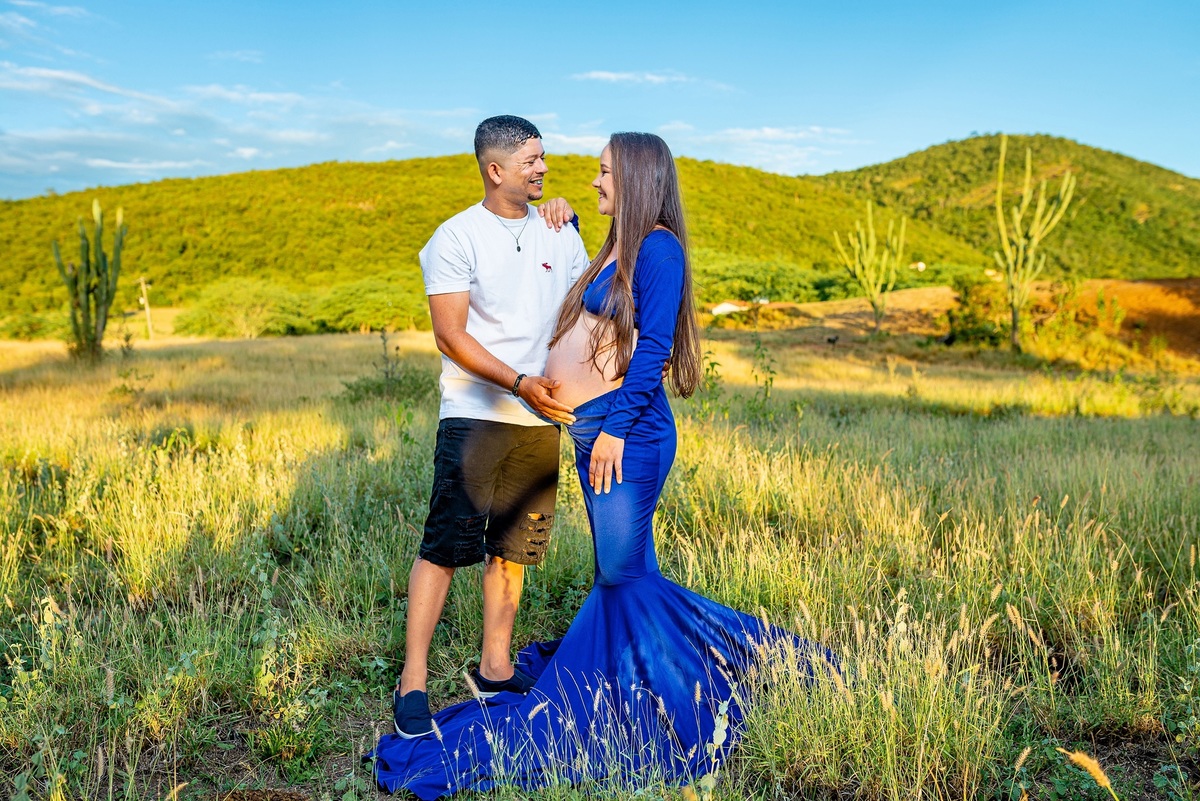 pai e mãe abraçados, pai com a mão na barriga da mãe que está gestante