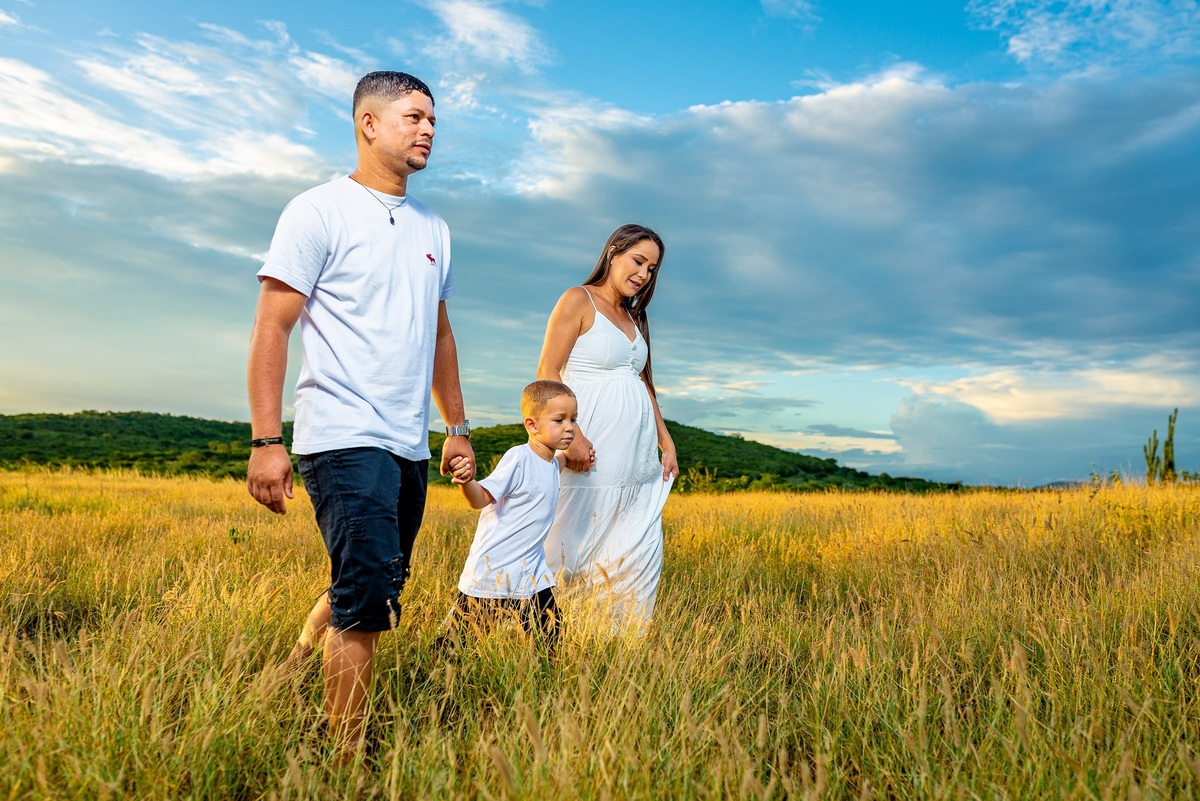 familia caminhando na relva, pai filho e mãe gestante