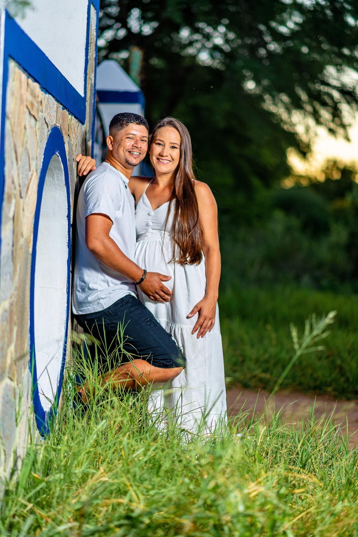 casal se beija no por do sol encostados na cancela da roça