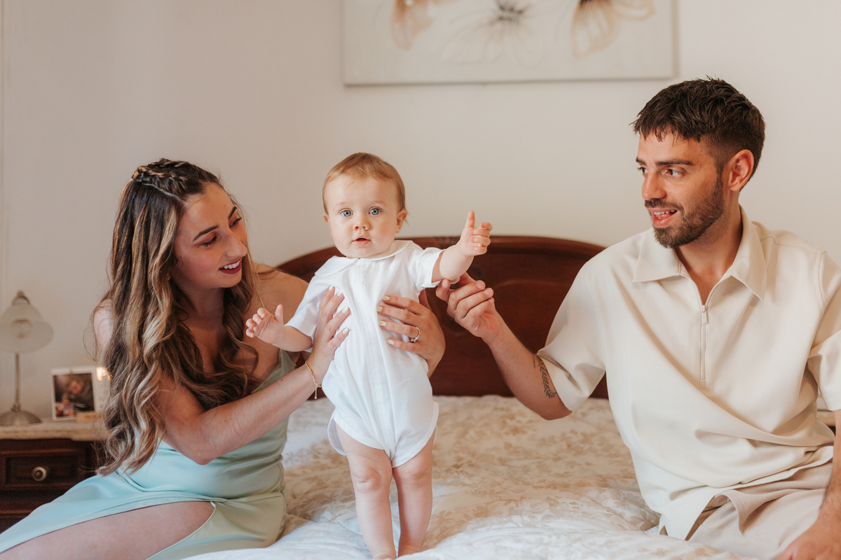 Registo fotográfico profissional de família cheia de afeto e conexão no batizado.