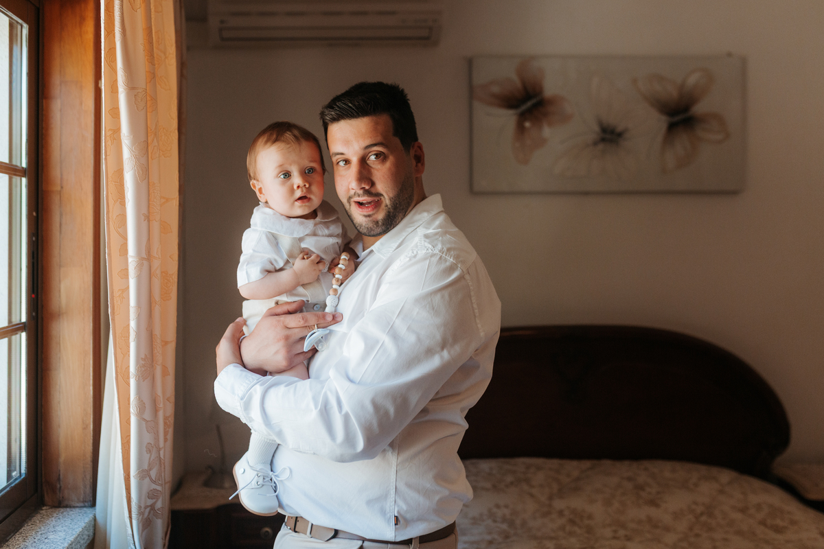 Registo fotográfico profissional de família cheia de afeto e conexão no batizado.