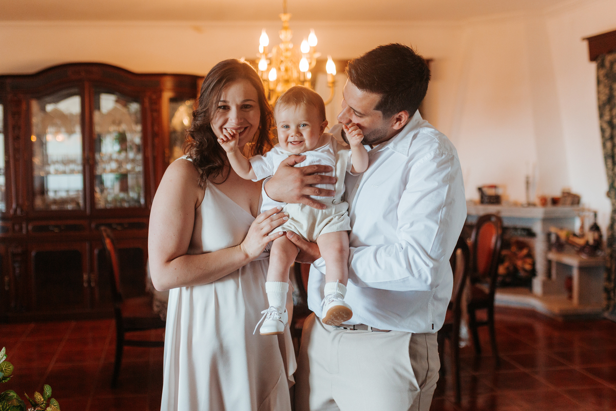 Registo fotográfico profissional de família cheia de afeto e conexão no batizado.