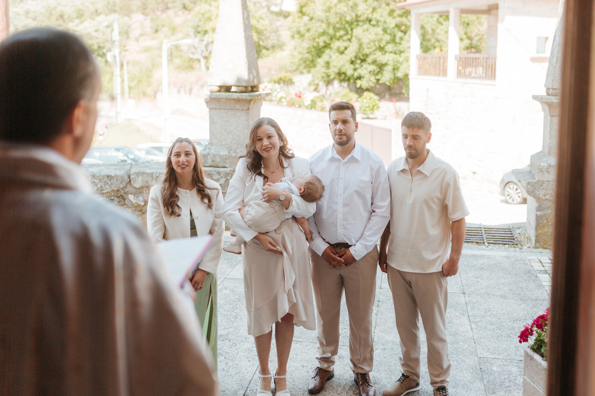 Registo fotográfico profissional de família cheia de afeto e conexão no batizado.