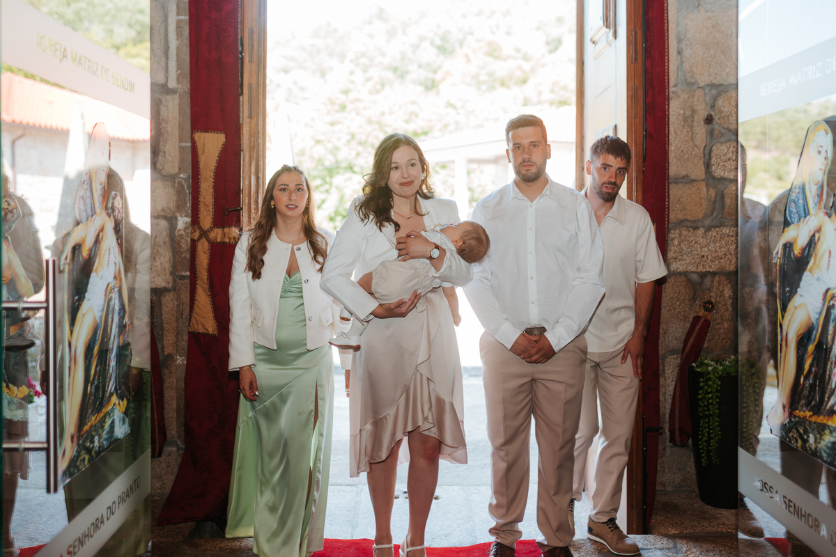Registo fotográfico profissional de família cheia de afeto e conexão no batizado.