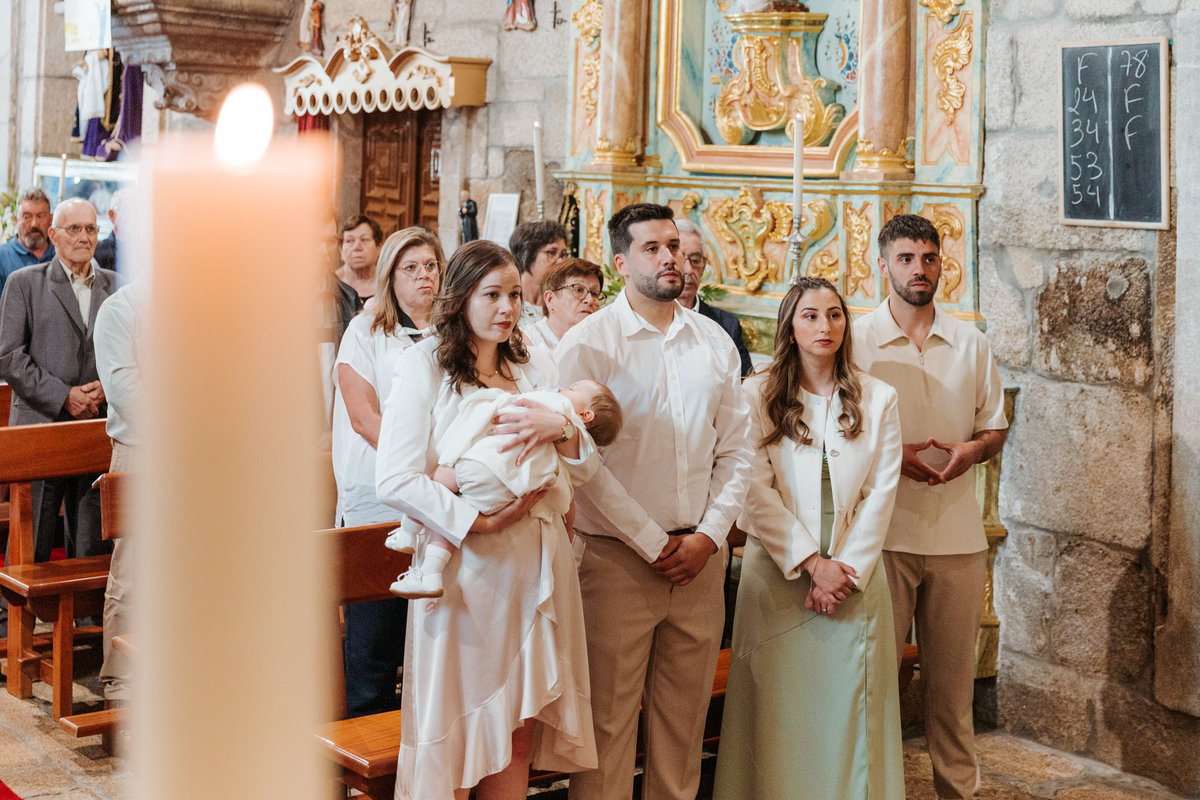 Registo fotográfico profissional de família cheia de afeto e conexão no batizado.