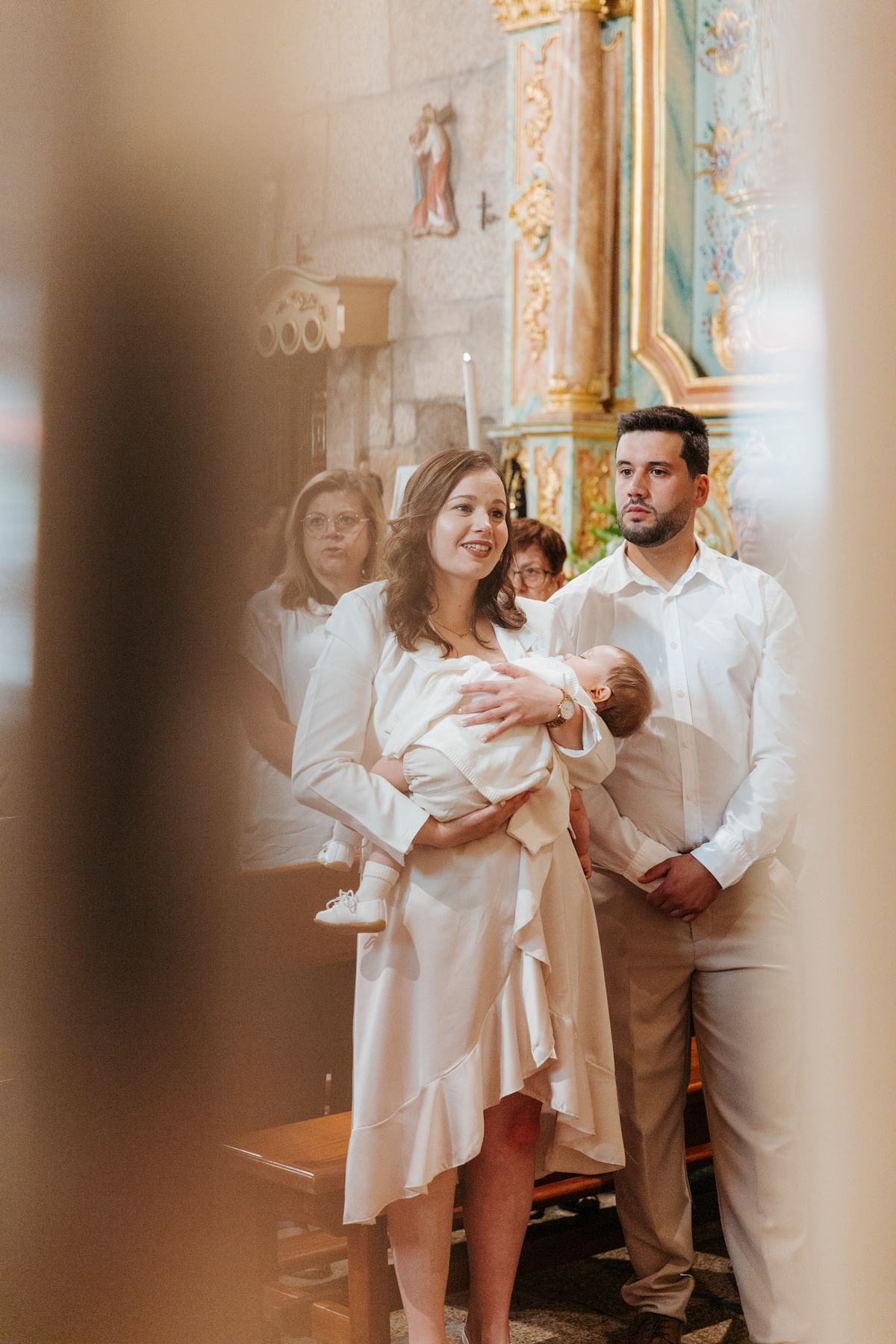 Registo fotográfico profissional de família cheia de afeto e conexão no batizado.