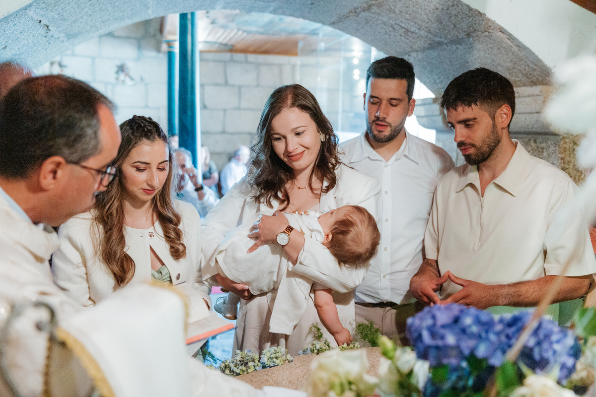 Registo fotográfico profissional de família cheia de afeto e conexão no batizado.