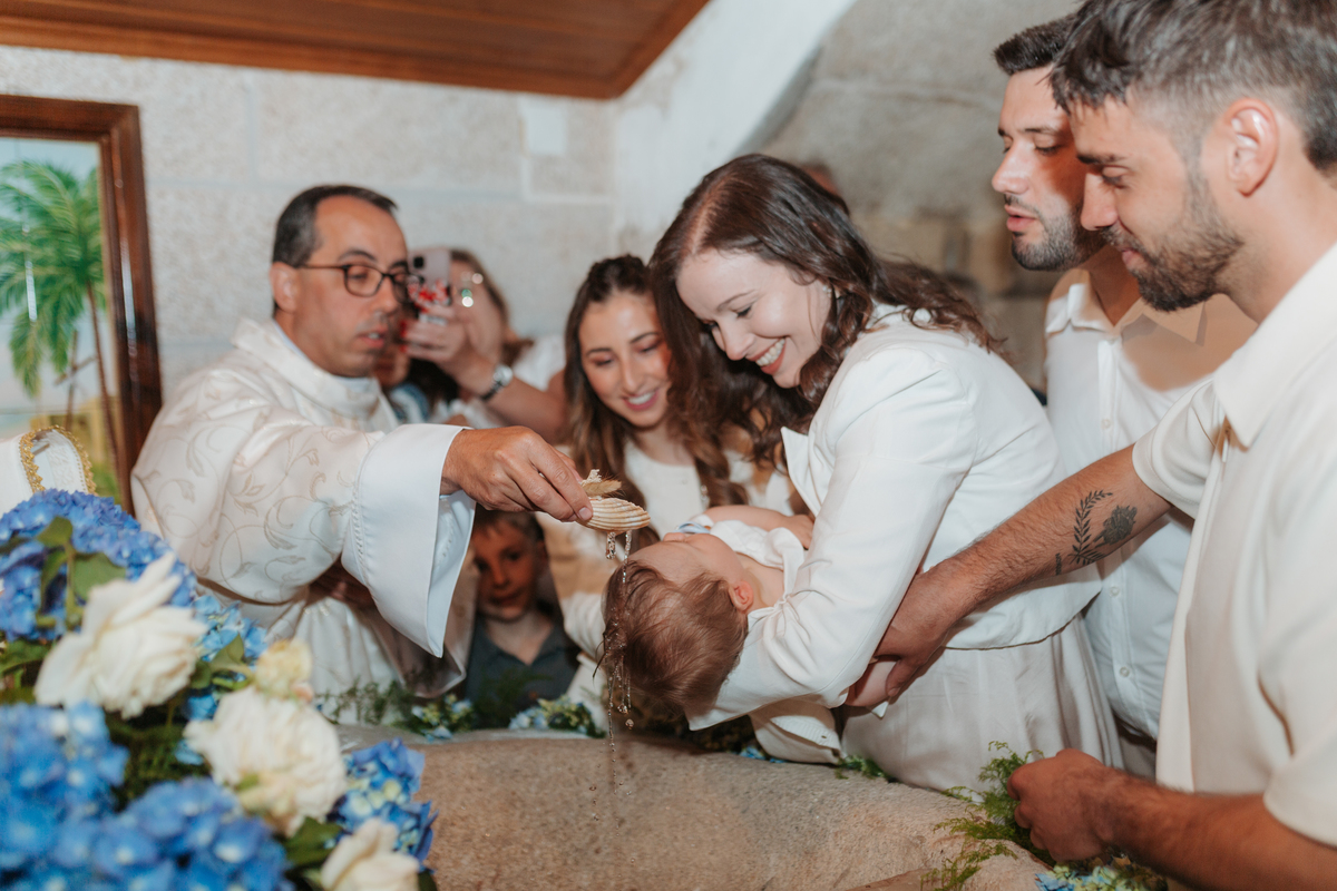 Registo fotográfico profissional de família cheia de afeto e conexão no batizado.