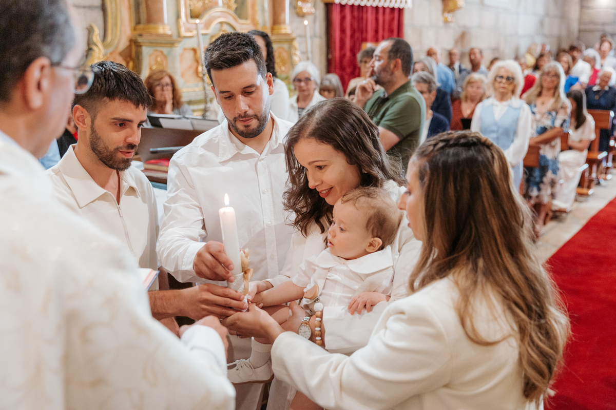 Registo fotográfico profissional de família cheia de afeto e conexão no batizado.