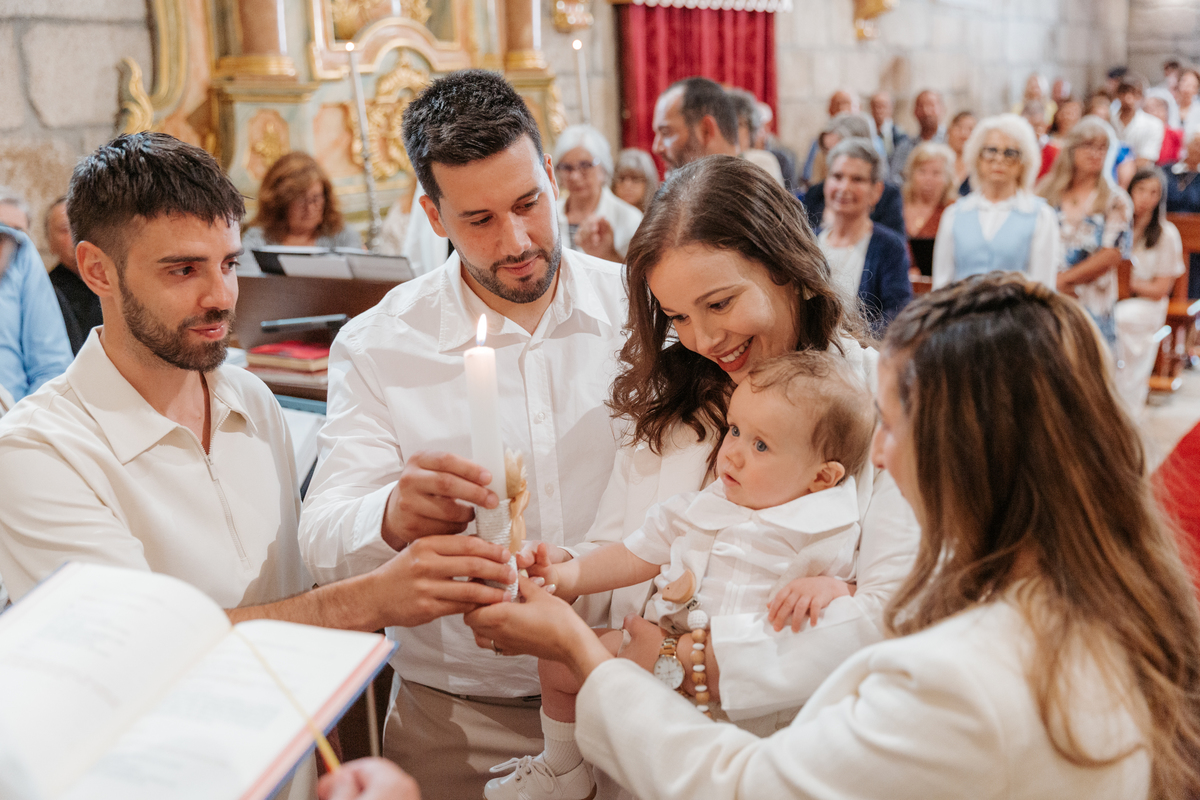 Registo fotográfico profissional de família cheia de afeto e conexão no batizado.