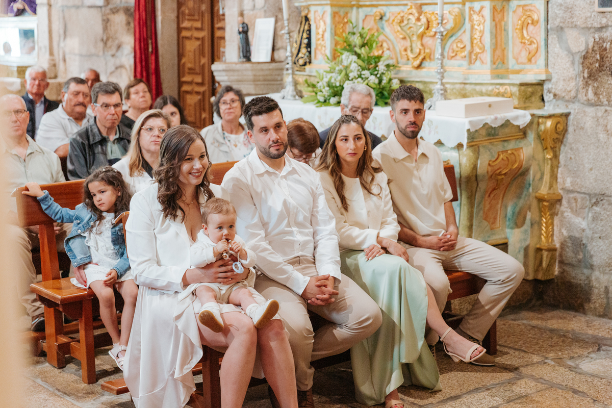 Registo fotográfico profissional de família cheia de afeto e conexão no batizado.