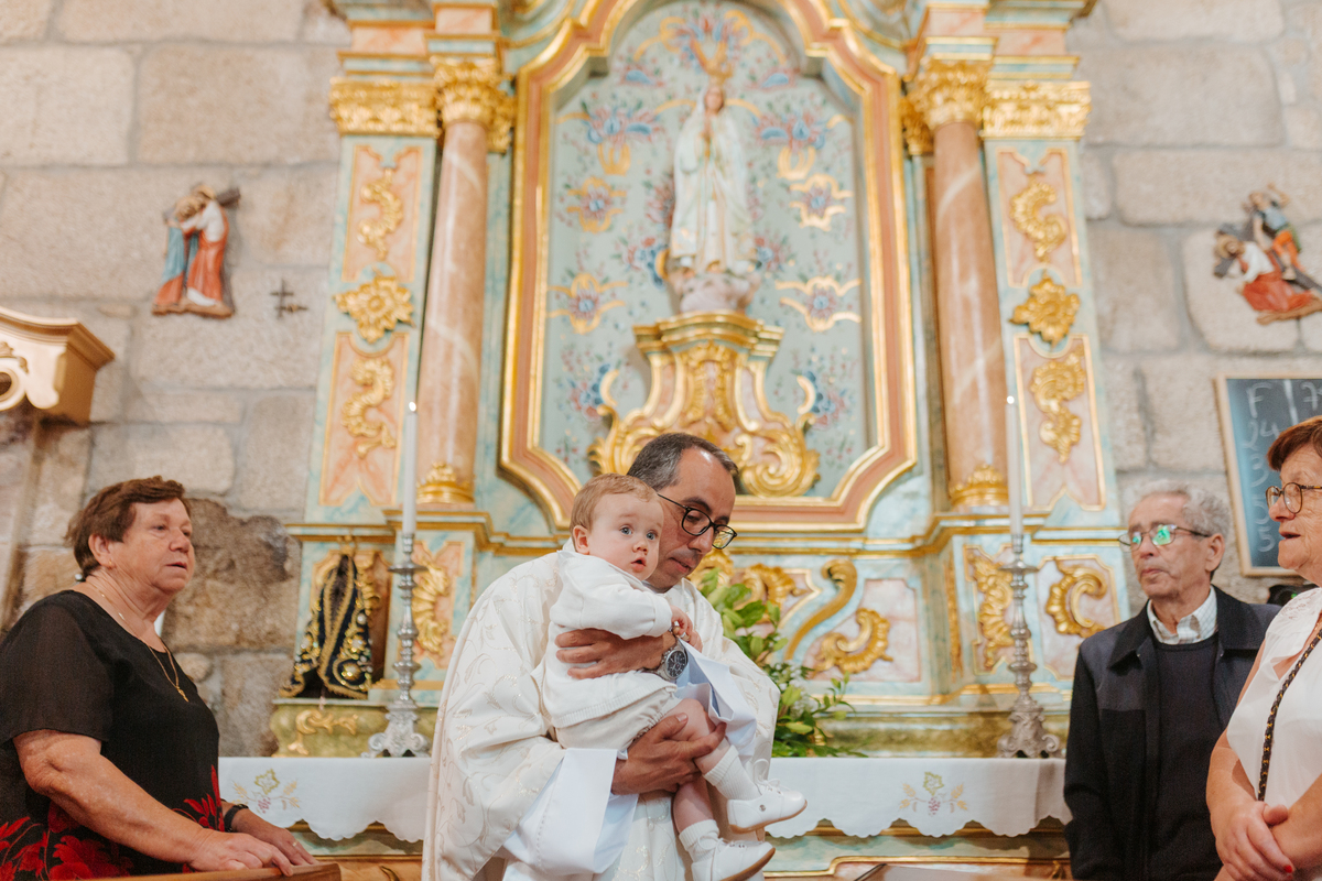 Registo fotográfico profissional de família cheia de afeto e conexão no batizado.