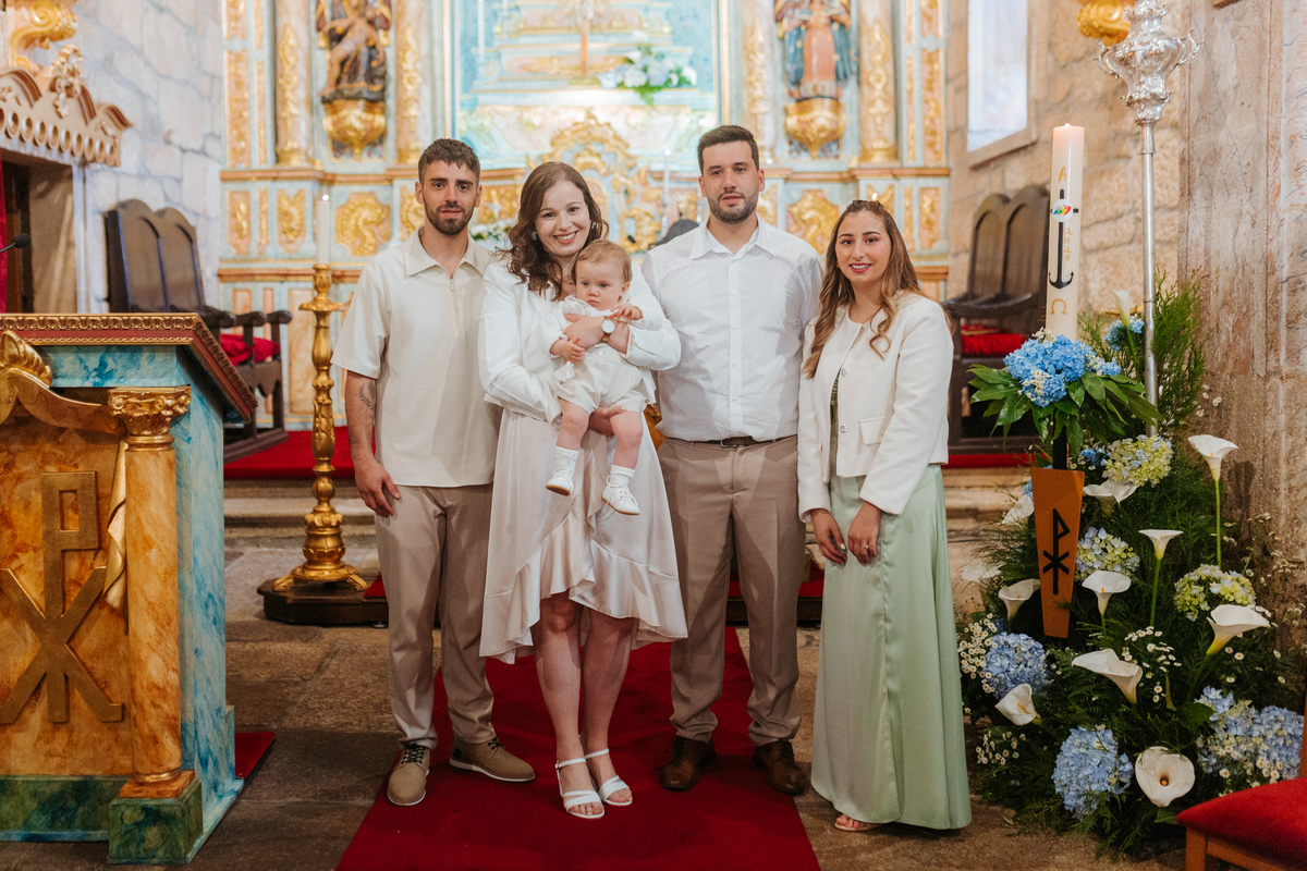 Registo fotográfico profissional de família cheia de afeto e conexão no batizado.