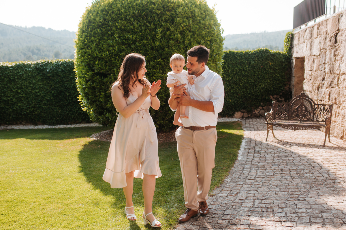 Registo fotográfico profissional de família cheia de afeto e conexão no batizado.