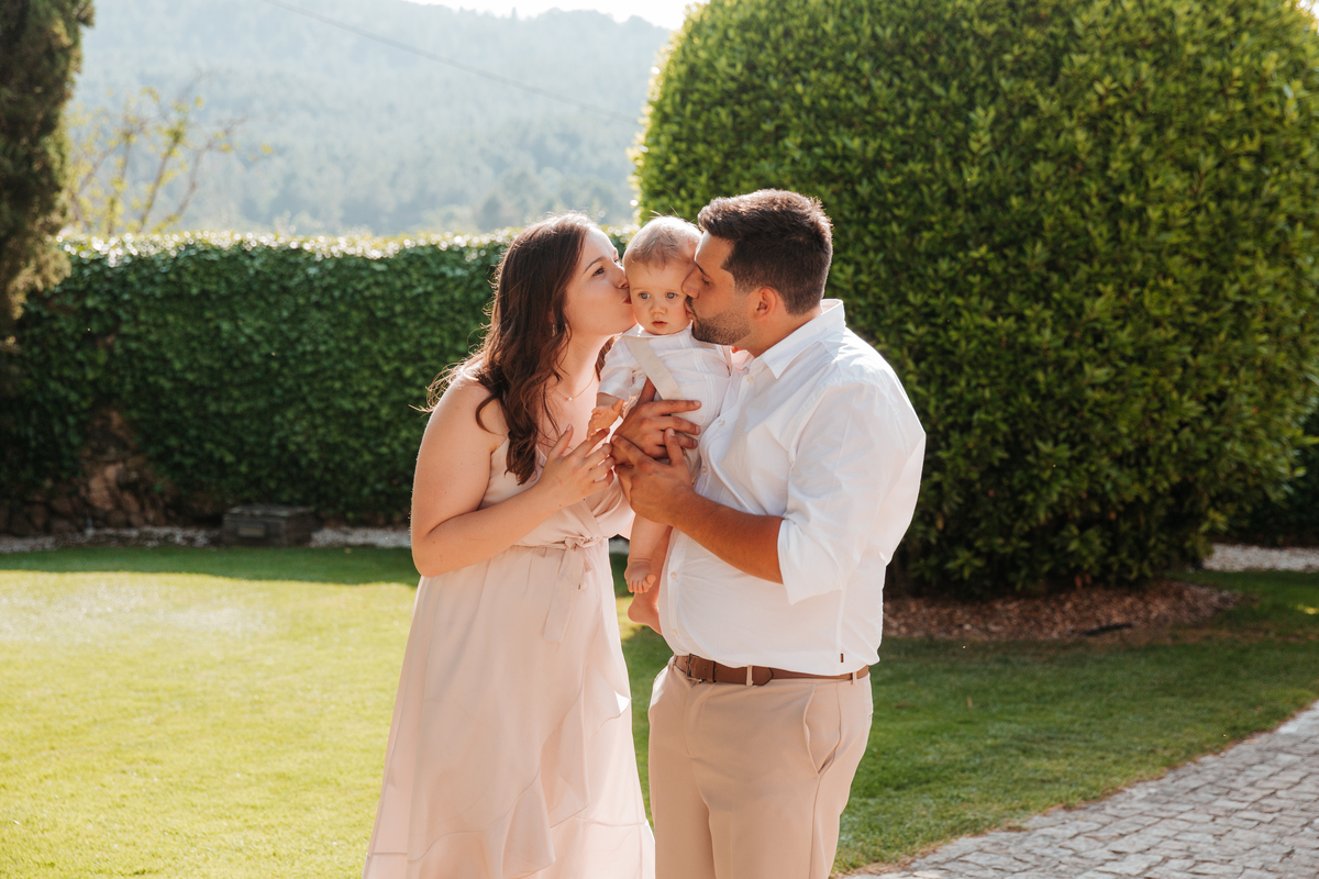 Registo fotográfico profissional de família cheia de afeto e conexão no batizado.