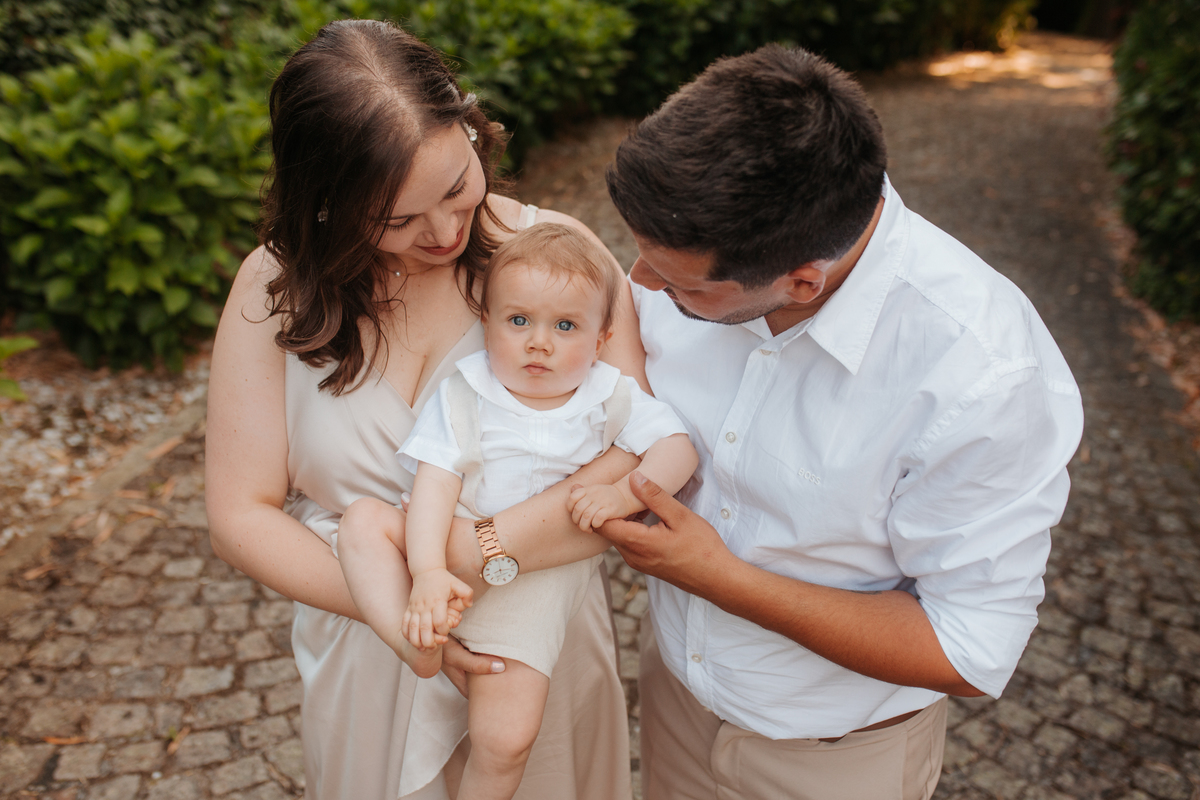 Registo fotográfico profissional de família cheia de afeto e conexão no batizado.