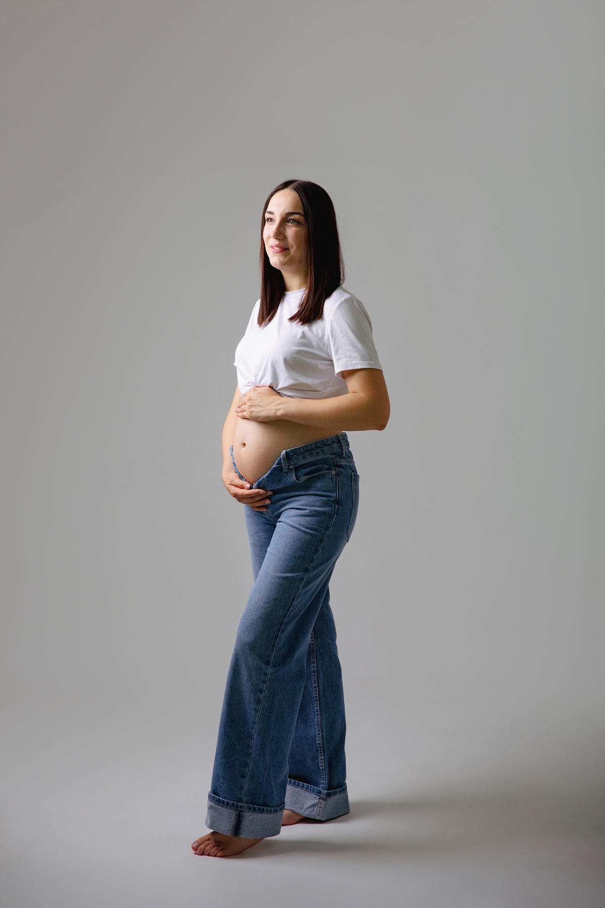 Fotografia de casal em estúdio para celebrar a revelação da gravidez com afeto.