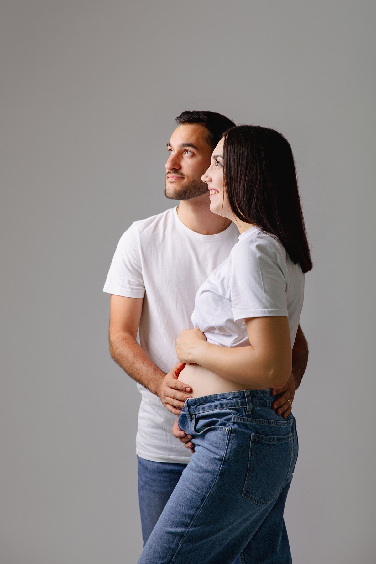 Fotografia de casal em estúdio para celebrar a revelação da gravidez com afeto.