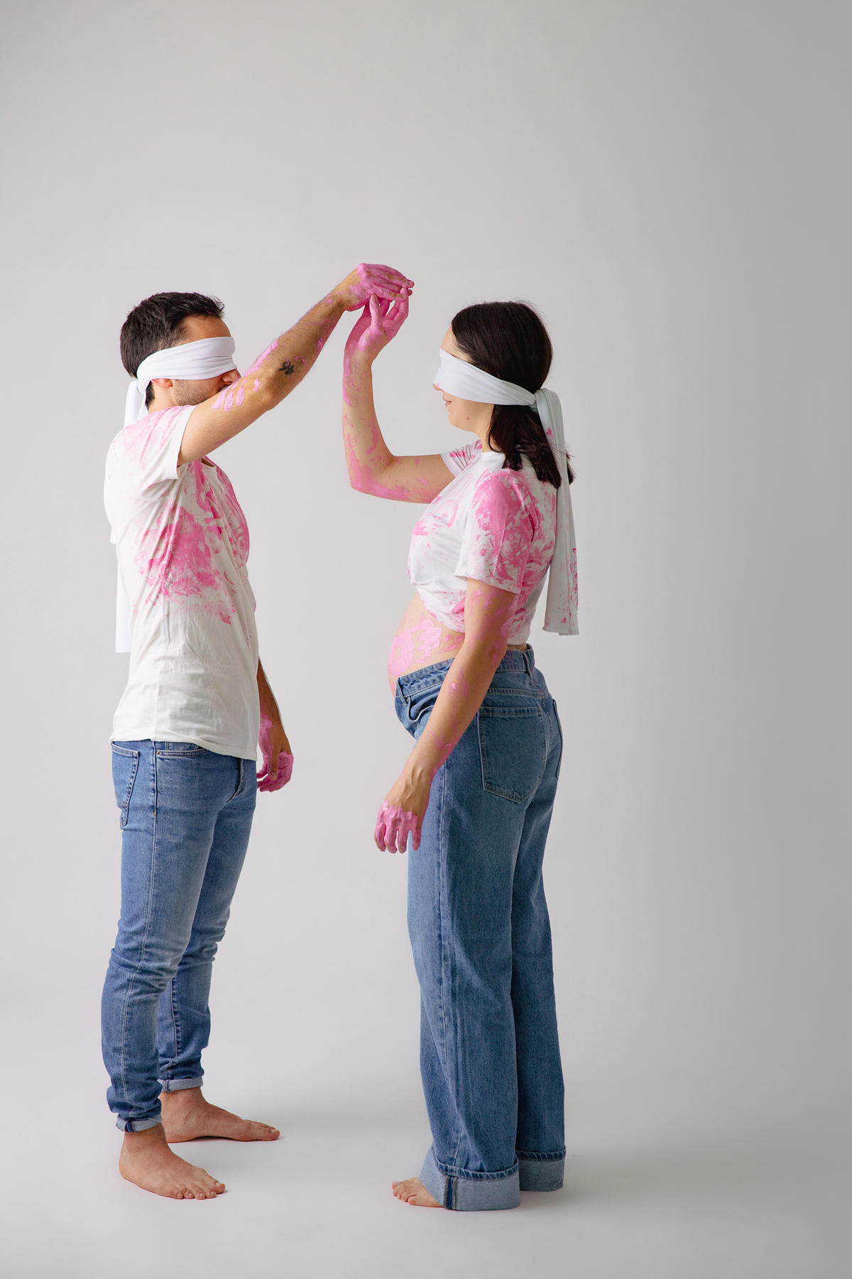 Fotografia de casal em estúdio para celebrar a revelação da gravidez com afeto.