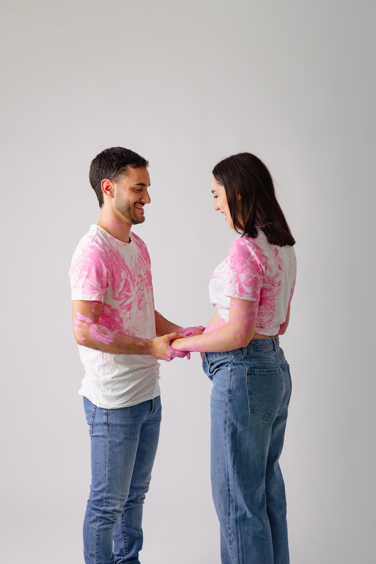 Fotografia de casal em estúdio para celebrar a revelação da gravidez com afeto.