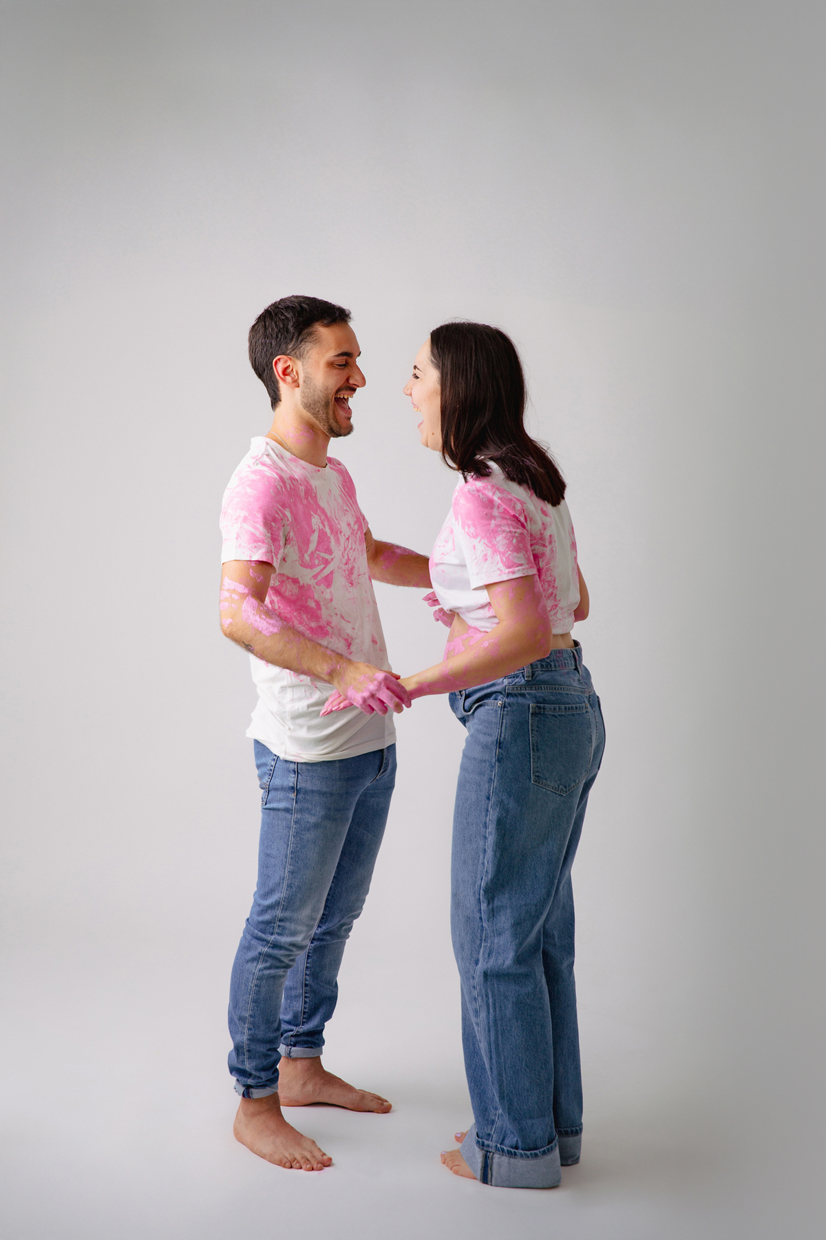 Fotografia de casal em estúdio para celebrar a revelação da gravidez com afeto.