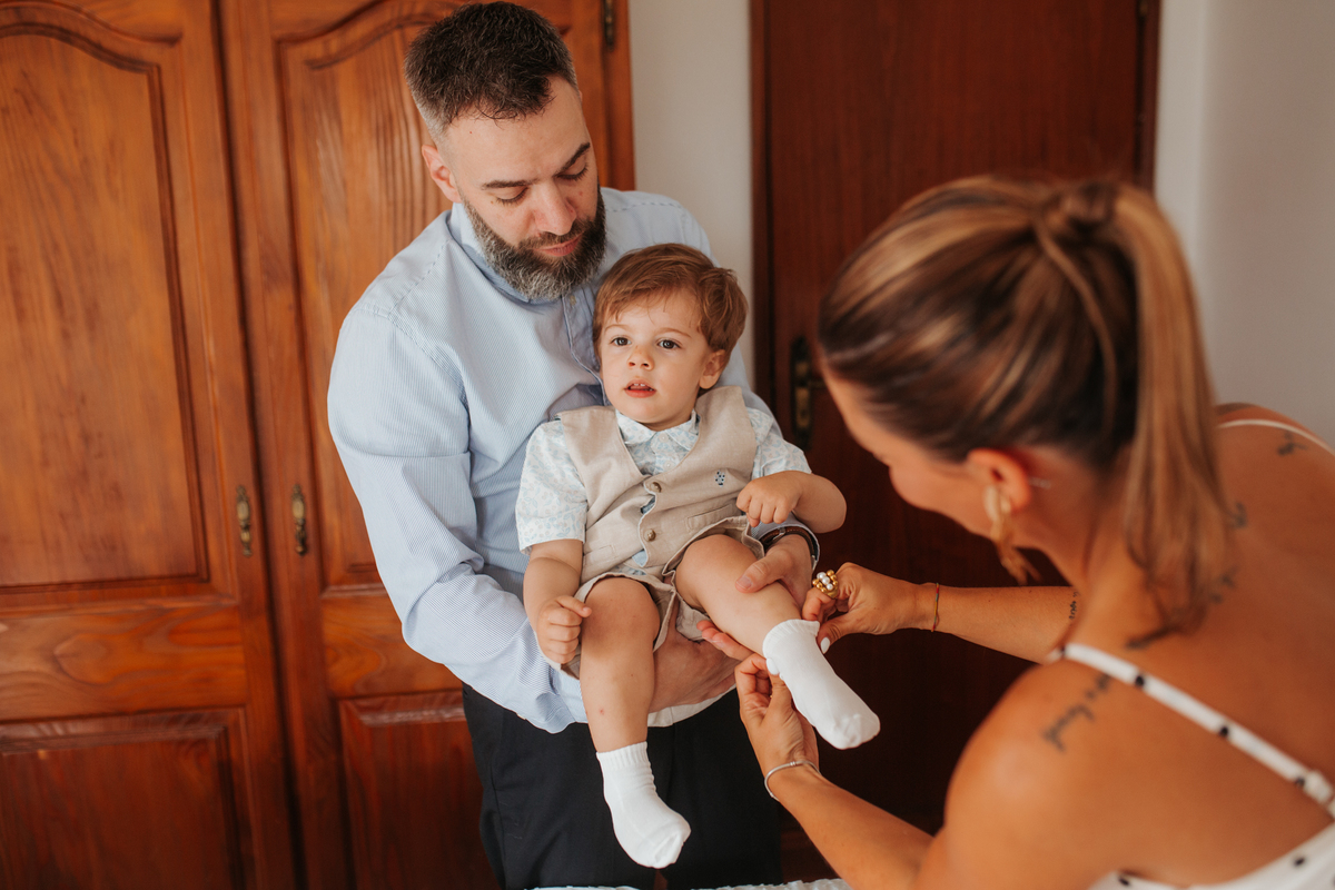 Momento de afeto e cumplicidade familiar na reportagem fotográfica de batizado.