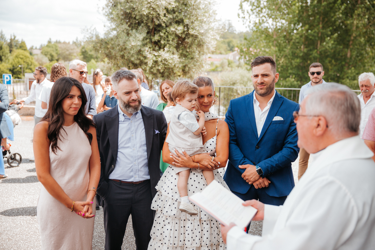 Momento de afeto e cumplicidade familiar na reportagem fotográfica de batizado.