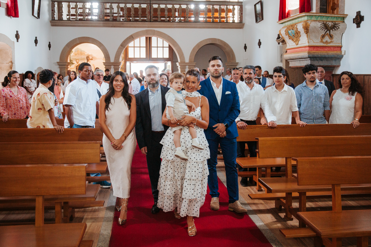 Momento de afeto e cumplicidade familiar na reportagem fotográfica de batizado.