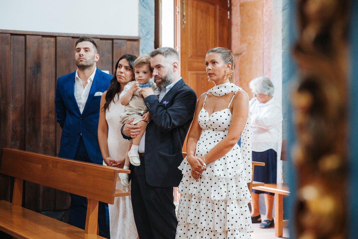 Momento de afeto e cumplicidade familiar na reportagem fotográfica de batizado.