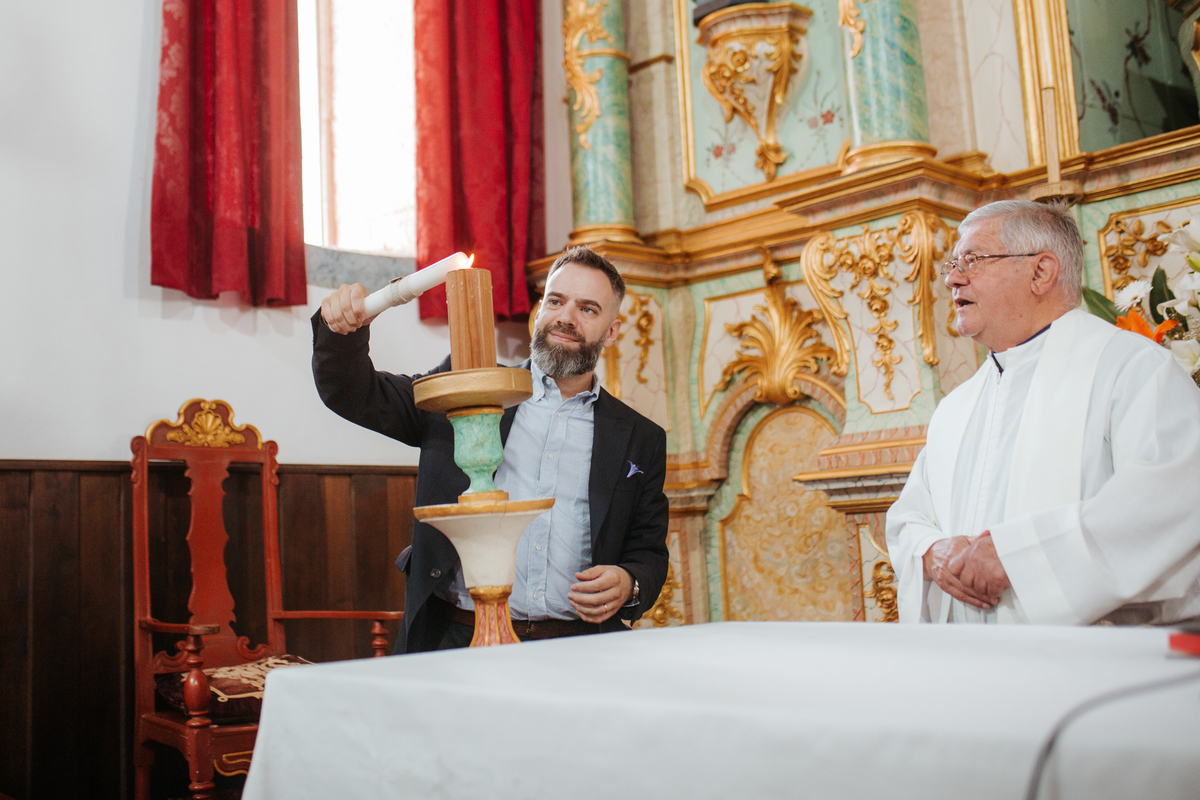 Momento de afeto e cumplicidade familiar na reportagem fotográfica de batizado.