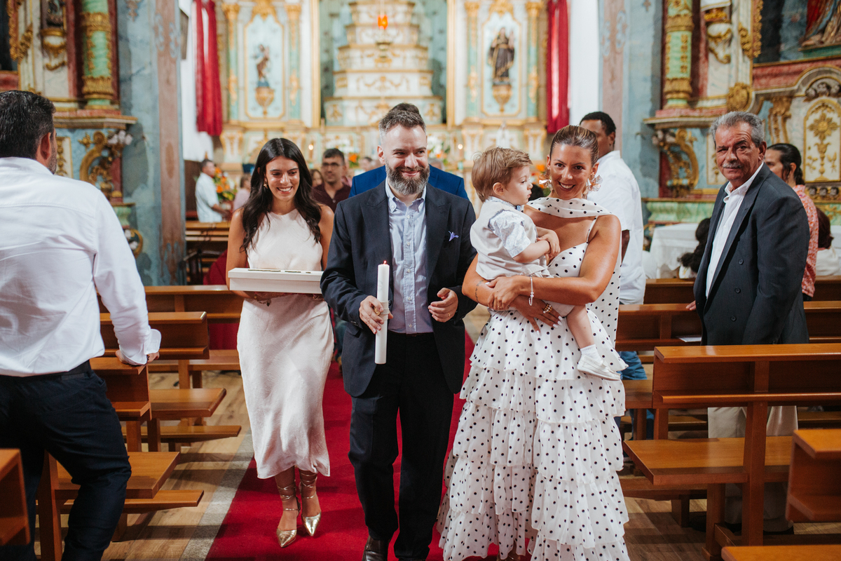 Momento de afeto e cumplicidade familiar na reportagem fotográfica de batizado.
