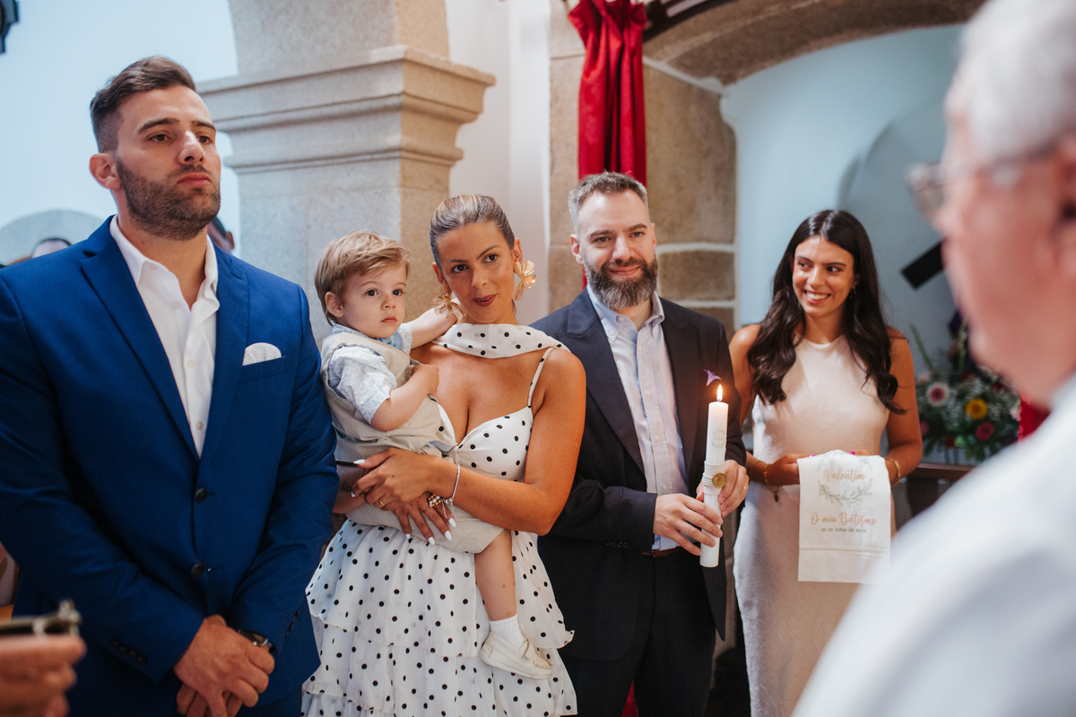 Momento de afeto e cumplicidade familiar na reportagem fotográfica de batizado.