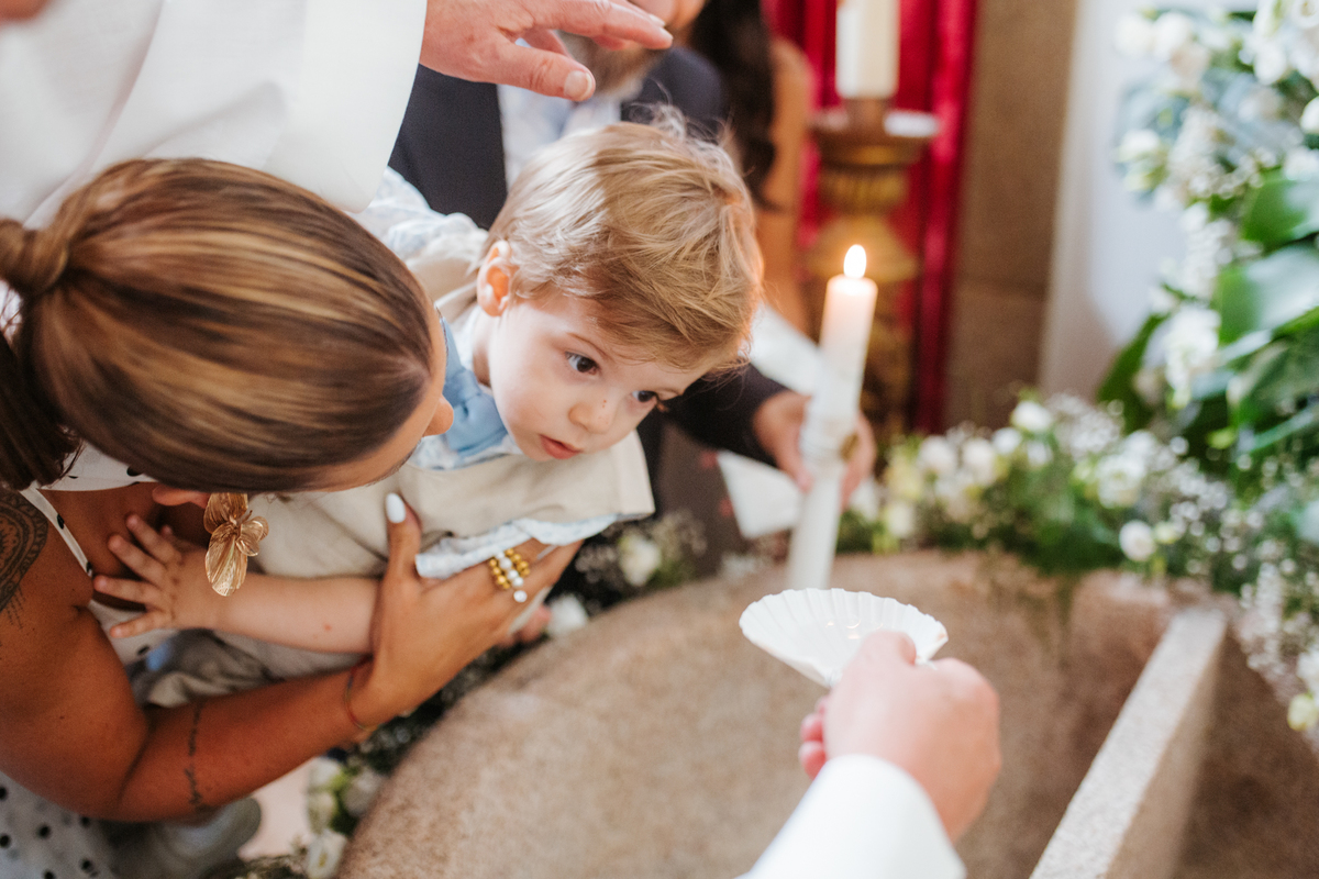 Momento de afeto e cumplicidade familiar na reportagem fotográfica de batizado.