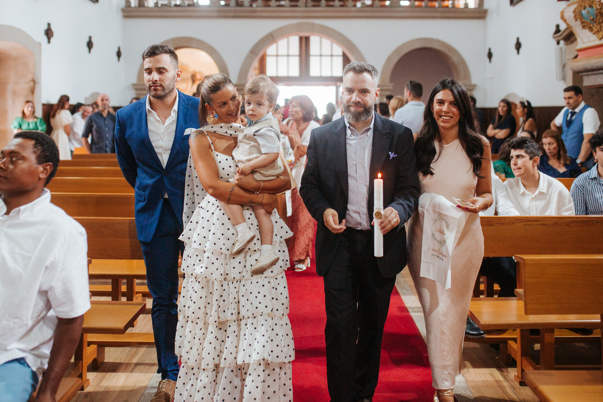 Momento de afeto e cumplicidade familiar na reportagem fotográfica de batizado.