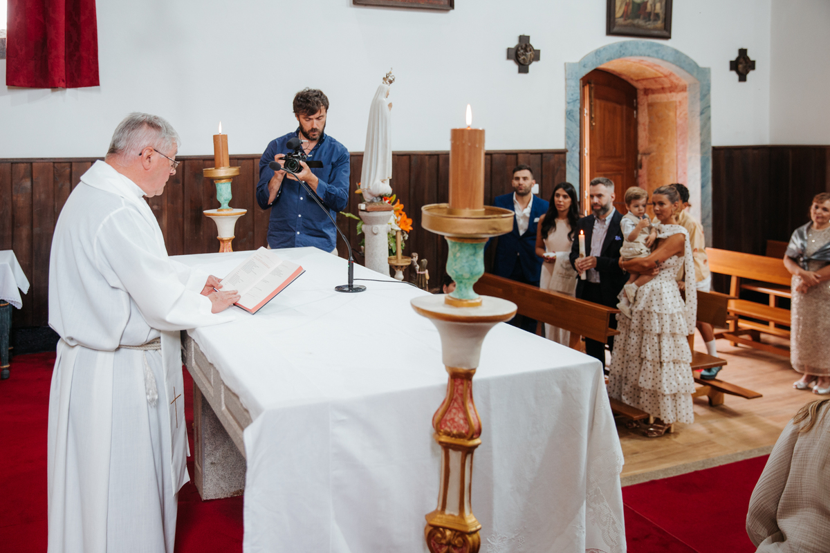 Momento de afeto e cumplicidade familiar na reportagem fotográfica de batizado.