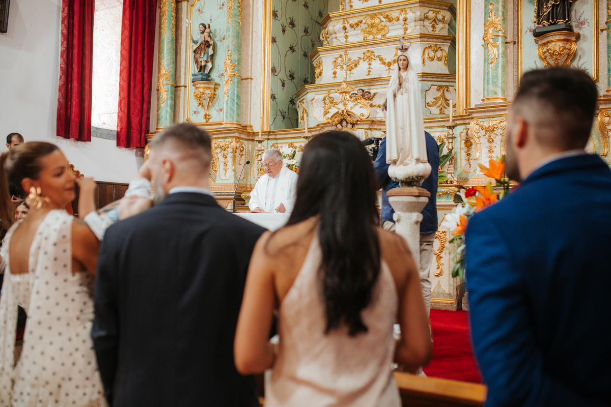 Momento de afeto e cumplicidade familiar na reportagem fotográfica de batizado.