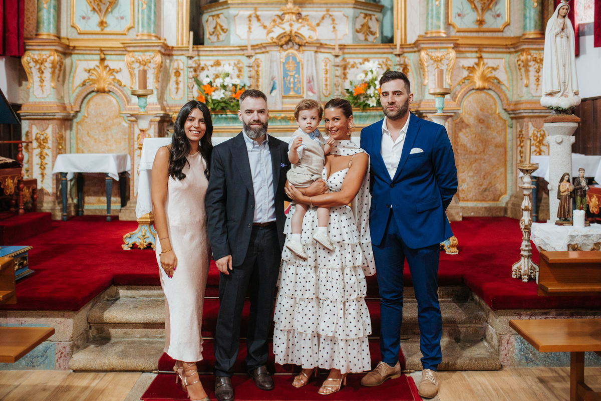 Momento de afeto e cumplicidade familiar na reportagem fotográfica de batizado.