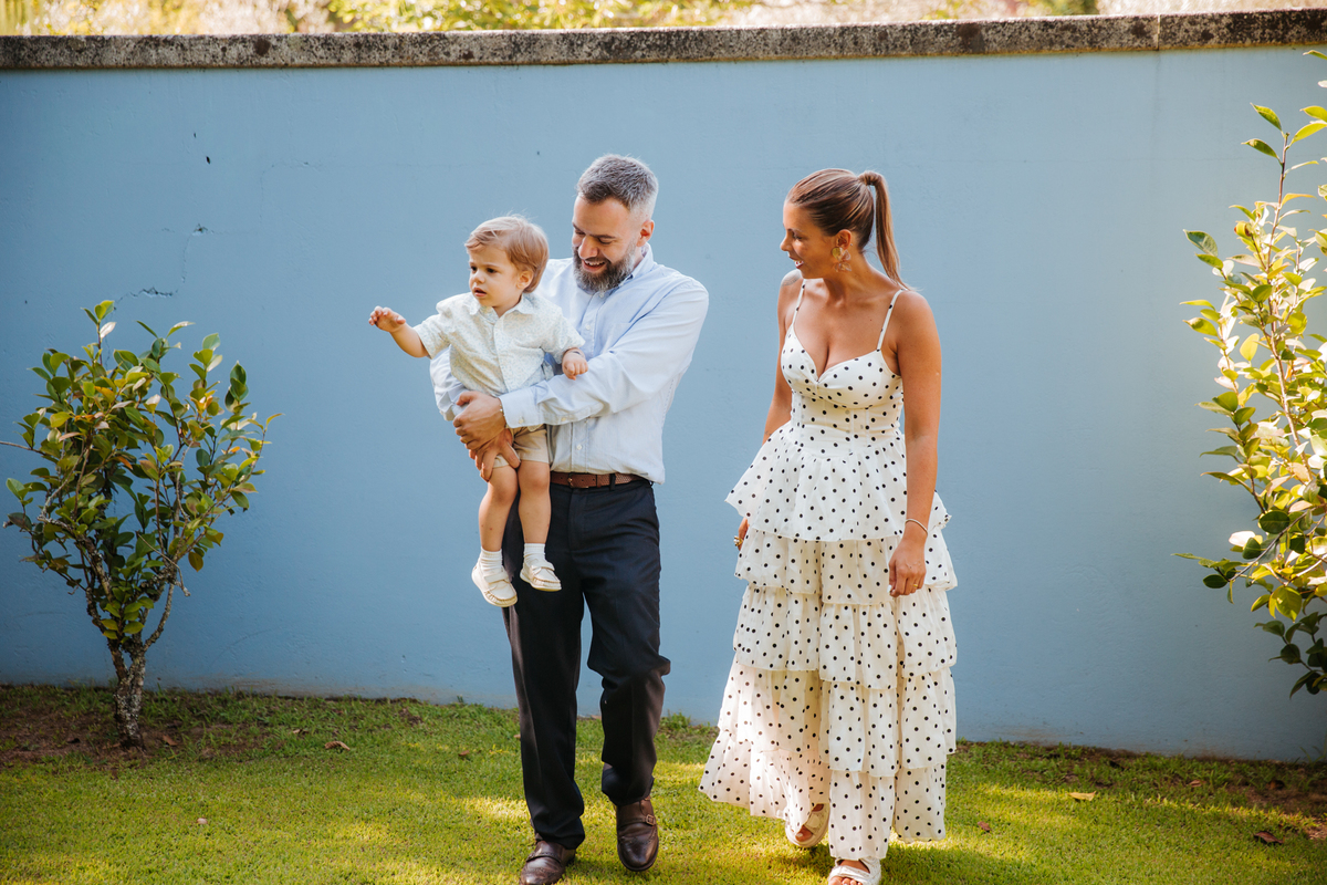 Momento de afeto e cumplicidade familiar na reportagem fotográfica de batizado.