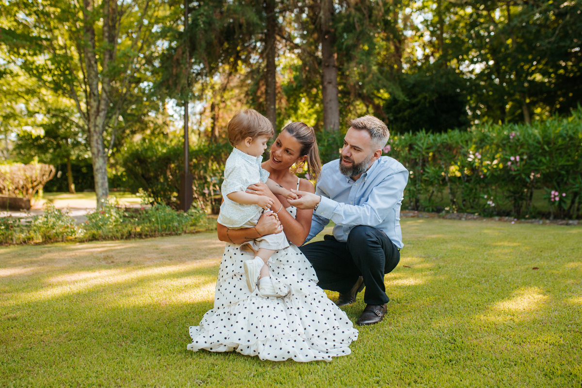 Momento de afeto e cumplicidade familiar na reportagem fotográfica de batizado.