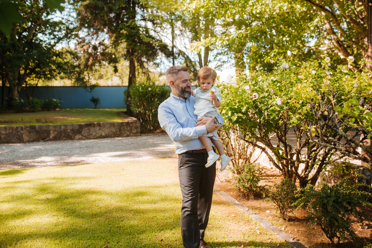 Momento de afeto e cumplicidade familiar na reportagem fotográfica de batizado.